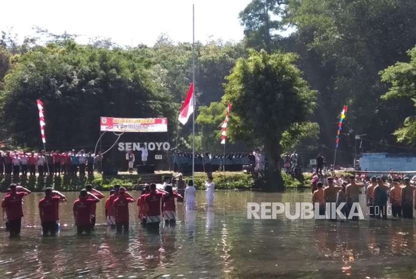 Warga Desa Tegalwaton, Kecamatan Tengaran, Kabupaten Semarang melaksanakan upacara bendera memperingati HUT Kemerdekaan RI ke-73 di kolam mata air Senjoyo, Jumat (17/8). Selain memperingati HUT Kemerdekaan RI kegiatan ini dilakukan untuk promosi wisata Pemandian Senjoyo.