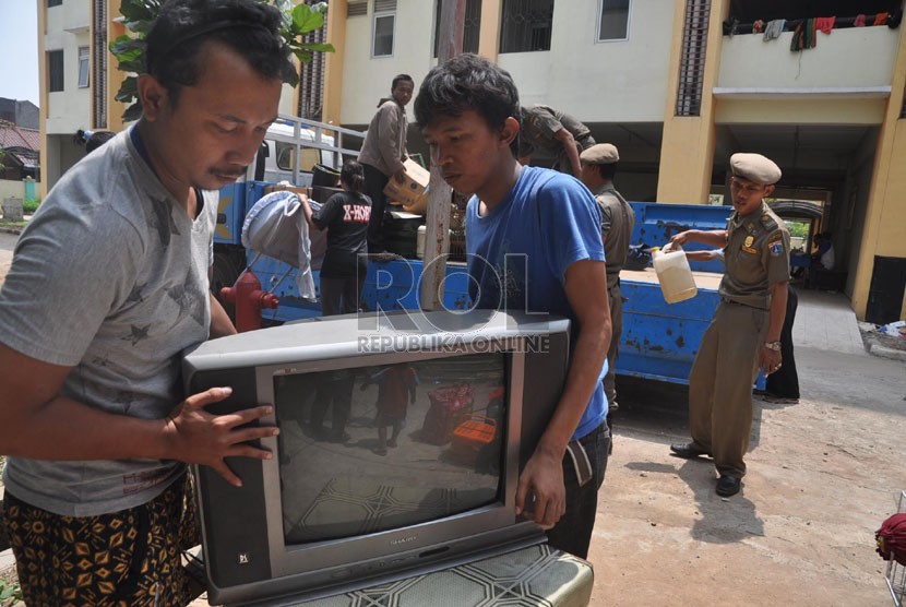    Warga di bantu oleh petugas Satpol PP menurunkan perabot mereka saat tiba di Rusun Pinus Elok, Jakarta Timur, Selasa (1/10).  (Republika/Rakhmawaty La'lang)