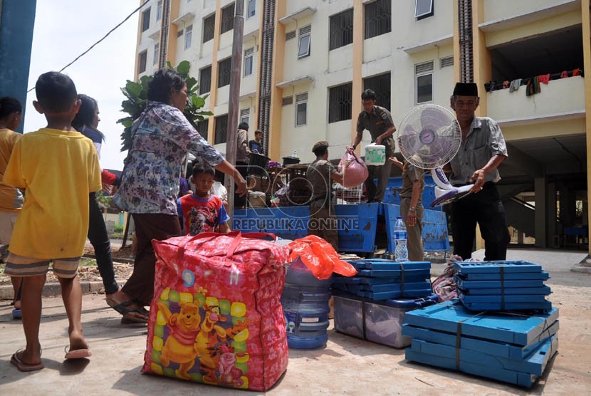    Warga di bantu oleh petugas Satpol PP menurunkan perabot mereka saat tiba di Rusun Pinus Elok, Jakarta Timur, Selasa (1/10).  (Republika/Rakhmawaty La'lang)