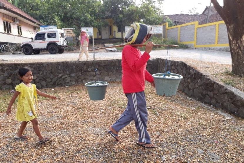 Warga di Desa Bojonggaling, Kecamatan Bantargadung, Kabupaten Sukabumi, Jawa Barat harus antri untuk mendapatkan air bersih yang disalurkan BPBD Sukabumi pada Senin (30/7) sore.