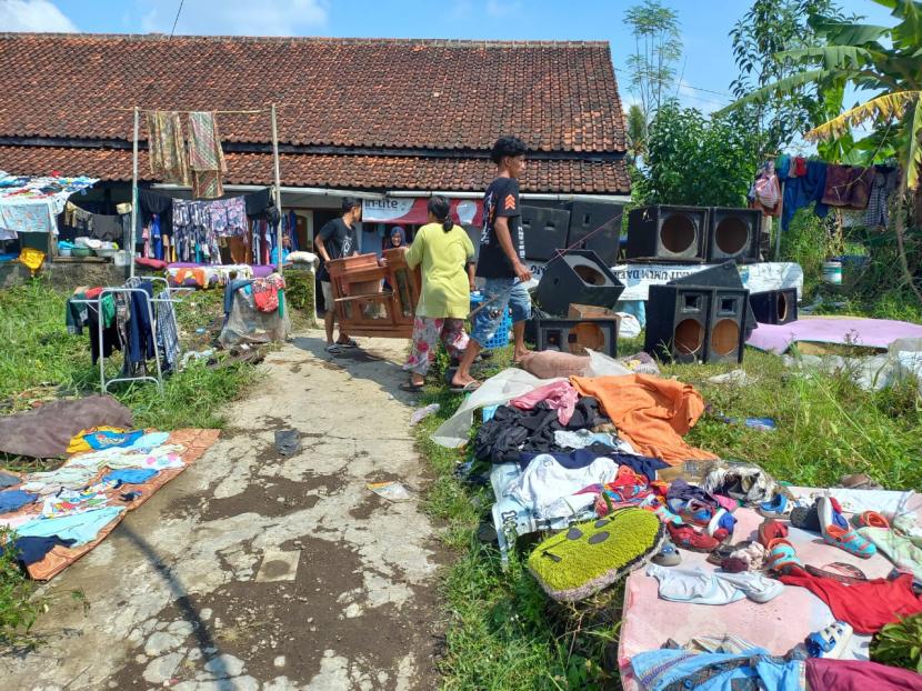 Warga di Kampung Sukasirna, Kelurahan Sukanagara, Kecamatan Purbaratu, Kota Tasikmalaya, membersihkan peralatan rumah tangga mereka, Ahad (17/4/2022). Banjir bandang menerjang wilayah itu pada Jumat (15/4/2022). 