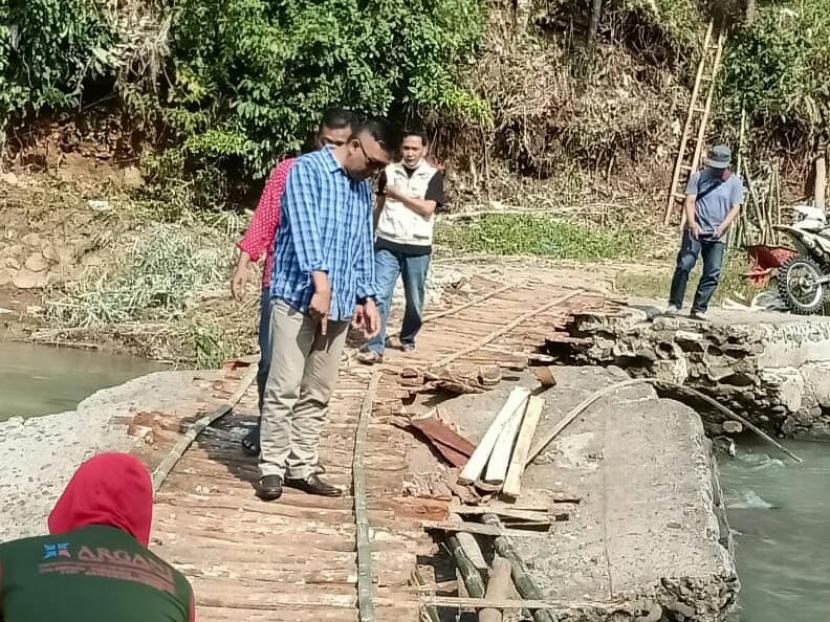 Warga di Kecamatan Cikatomas, Kabupaten Tasikmalaya, membuat jembatan darurat agar bisa menyeberang Sungai Cimedang, lantaran jembatan utama di lokasi itu terputus akibat banjir bandang