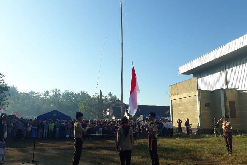 Warga di pos pengungsian di Dusun Pakel, Desa Gunungsari, Kecamatan Gunungsari, Kabupaten Lombok Barat, Nusa Tenggara Barat (NTB) menggelar upacara bendera di pos pengungsian pada Jumat (17/8).