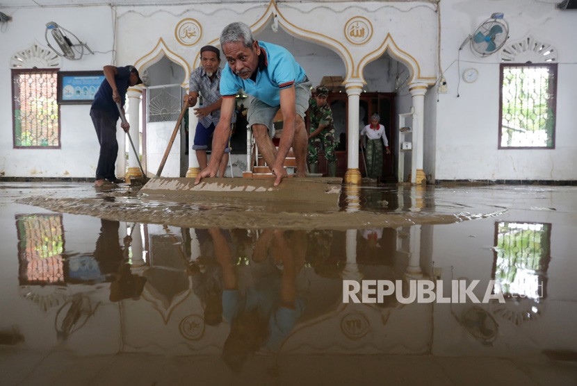 Warga dibantu aparat TNI membersihkan lumpur yang mengenangi lantai masjid pascabencana banjir di Desa Pulo Tinggi, Kecamatan Pasie Raya, Aceh Jaya, Aceh, Rabu (17/10/2018). 