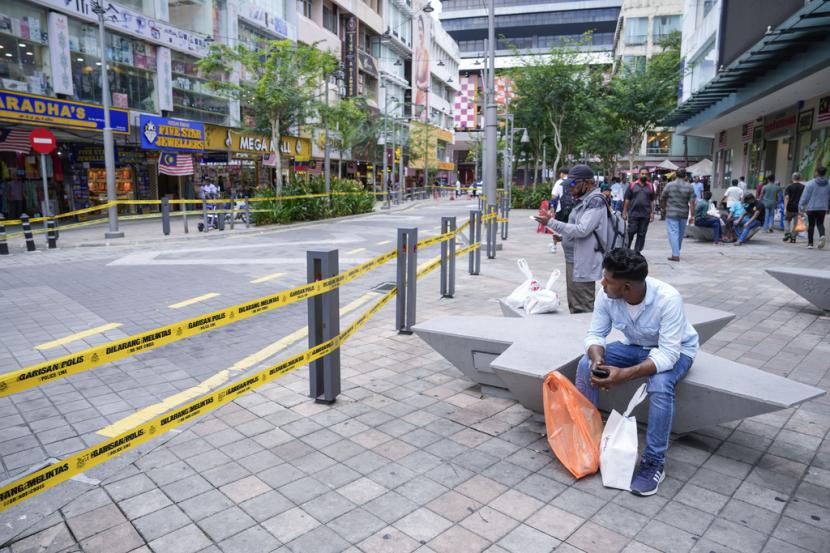 Warga duduk dekat jalanan yang ditutup setelah satu lagi sinkhole muncul setelah WN India ambles ke dalam sinkhole di KL, Malaysia, 29 Agustus 2024. 