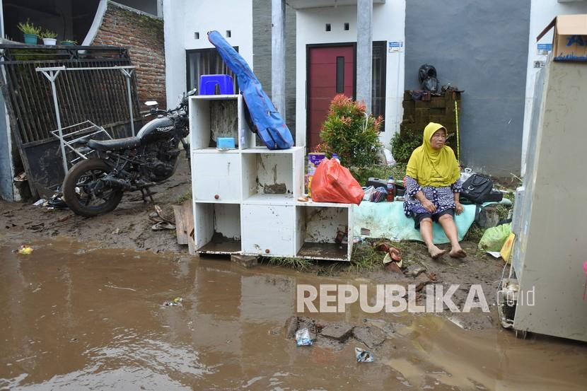Warga duduk di depan rumahnya pascabanjir di salah satu perumahan di Kelurahan Tegal Besar, Kaliwates, Jember, Jawa Timur, Sabtu (30/1). Pada Sabtu (6/2), banjir kembali melanda tiga kecamatan di Kabupaten Jember.