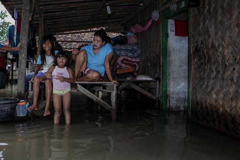 Warga duduk di halaman rumahnya yang terendam banjir di Pakuhaji, Kabupaten Tangerang, Banten, Kamis (20/1/2022). Intensitas hujan yang tinggi sejak Selasa (18/1) menyebabkan empat kampung di kecamatan tersebut terendam banjir dan mengakibatkan 660 KK terdampak.