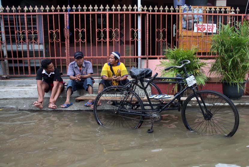   Warga duduk di pinggir jalan saat banjir melanda perumahan Ciledug indah 1, Ciledug, Tangerang, Banten, Kamis (16/1).    (Republika/Yasin Habibi)