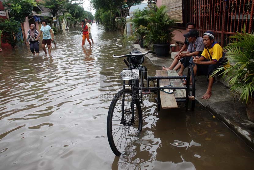   Warga duduk di pinggir jalan saat banjir melanda perumahan Ciledug indah 1, Ciledug, Tangerang, Banten, Kamis (16/1).    (Republika/Yasin Habibi)