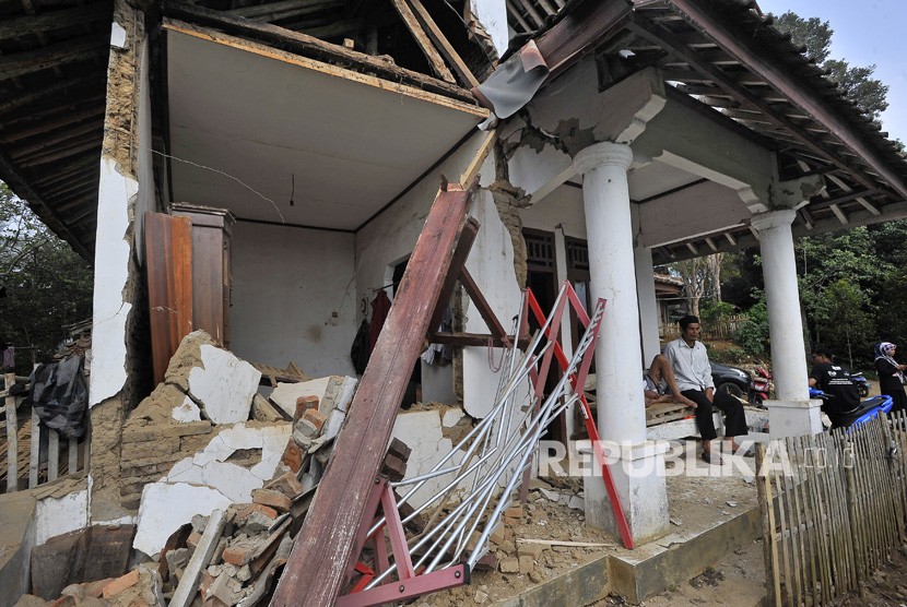 Warga duduk di rumahnya yang rusak akibat diguncang gempa di Kampung Karoya, Mandalawangi, Pandeglang, Banten, Sabtu (3/8/2019).
