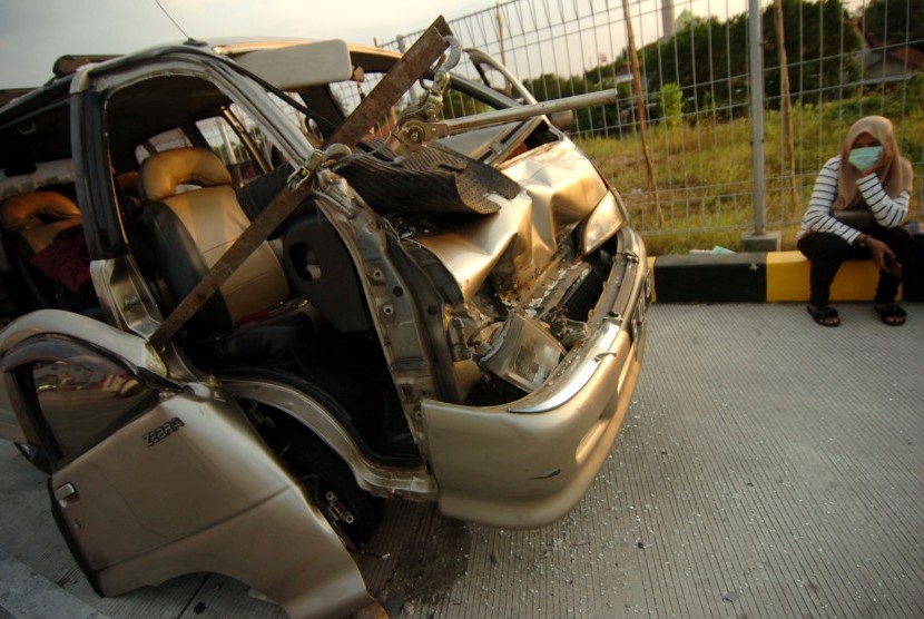 Warga duduk di samping kendaraannya yang hancur akibat kecelakaan beruntun di jalan tol Pejagan-Pemalang, Jawa Tengah. (ilustasi)