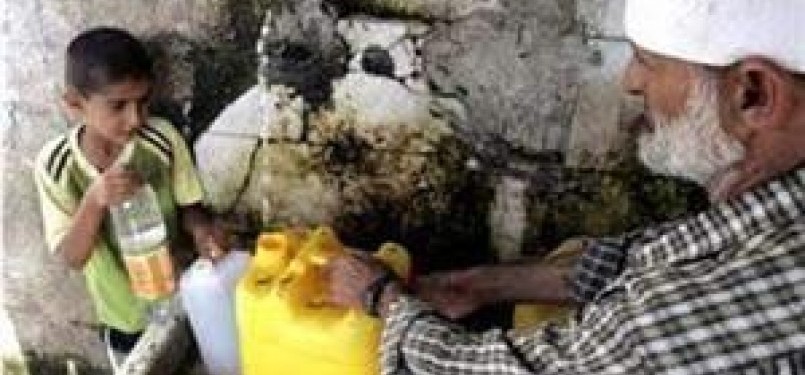 Warga Gaza mengambil air minum di sebuah pompa air.