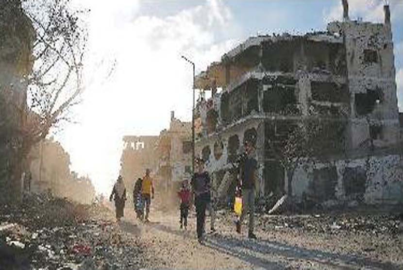Warga Gaza, Rabu(6/8),berjalan di antara reruntuhan puing bangunan di Shujaiya yang di bombardir militer Israel.