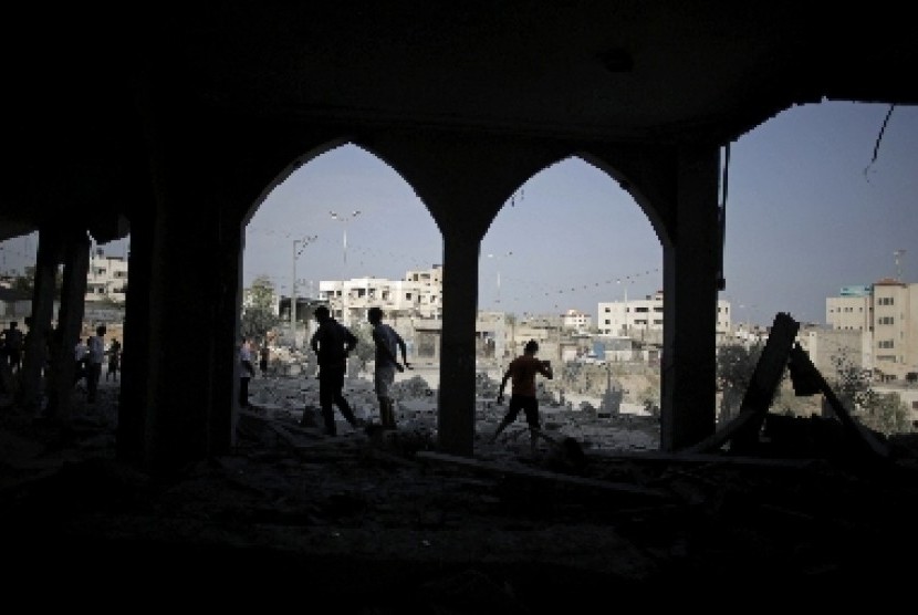 Warga Gaza tengah melihat puing reruntuhan masjid yang hancur akibat serangan Israel.