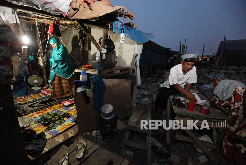 Warga gusuran Pasar Ikan berbuka puasa di Penjaringan, Jakarta Utara,Selasa (7/6).  (Republika/Rakhmawaty La'lang)
