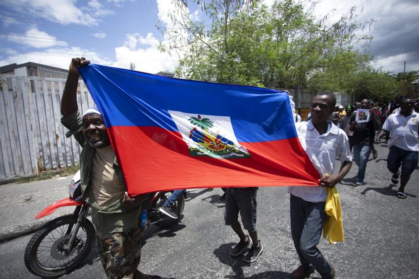 Warga Haiti membawa bendera di Port-au-Prince, Haiti, Jumat (15/7/2022).