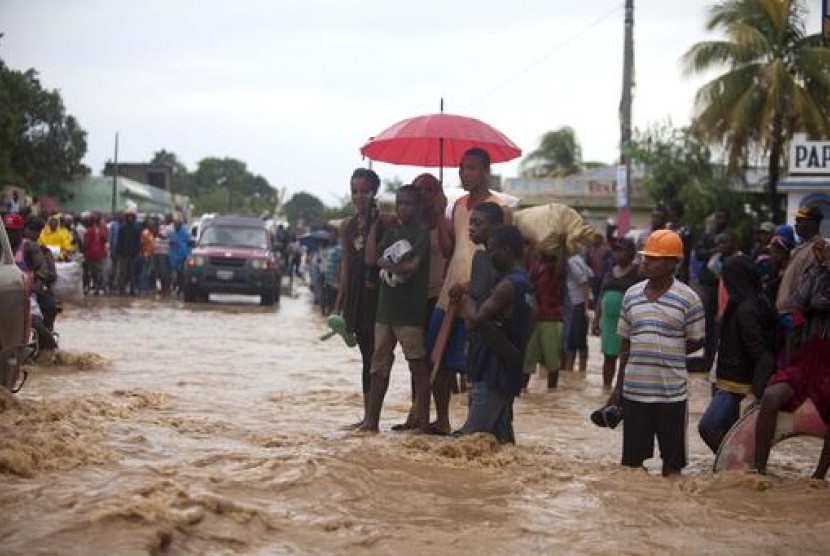Warga Haiti menyaksikan jalan yang banjir akibat Topan Matthew di Leogane, Haiti, Rabu, 5 Oktober 2016.