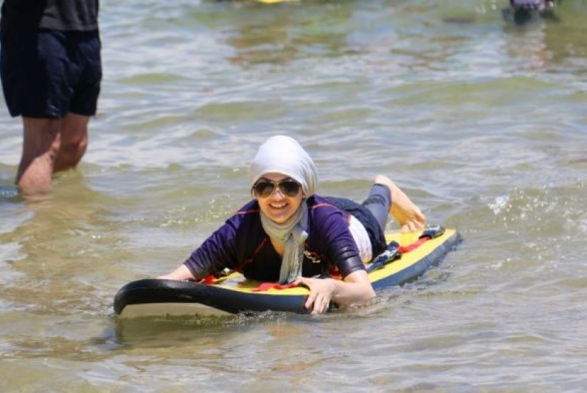 Warga imigran yang baru tiba di Australia bermain di pantai sebelum menjadi terbiasa di air.