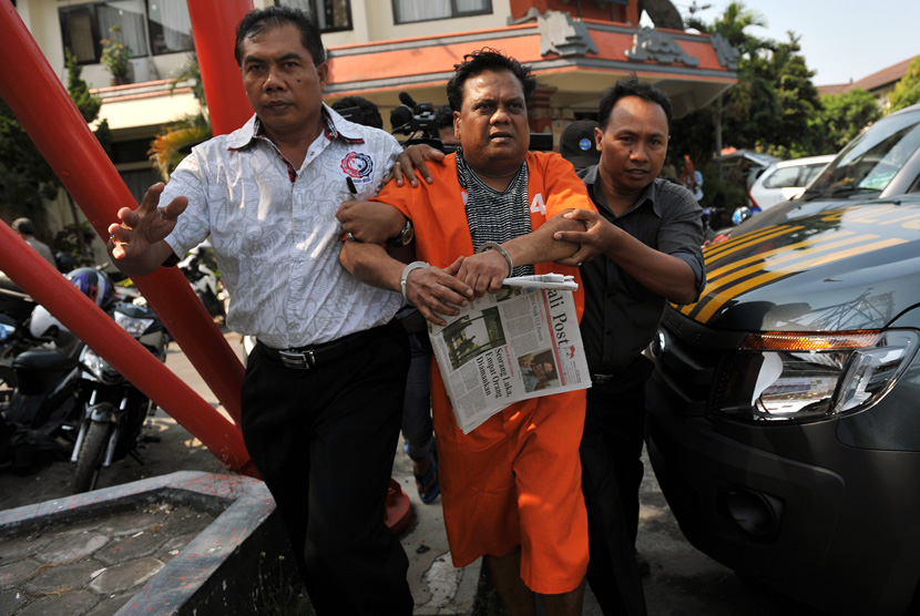 Warga India yang menjadi buronan negaranya, Rajendra Sadashiv Nikalje (tengah) digiring polisi seusai diperiksa di Mapolda Bali, Denpasar, Kamis (29/10). 