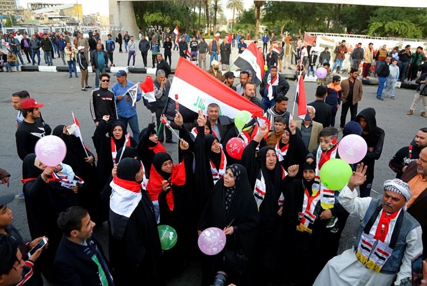 Warga Irak merayakan kemenangan militer yang berhasil mengalahkan ISIS di Tahrir Square, Baghdad, Irak, Ahad (10/12).