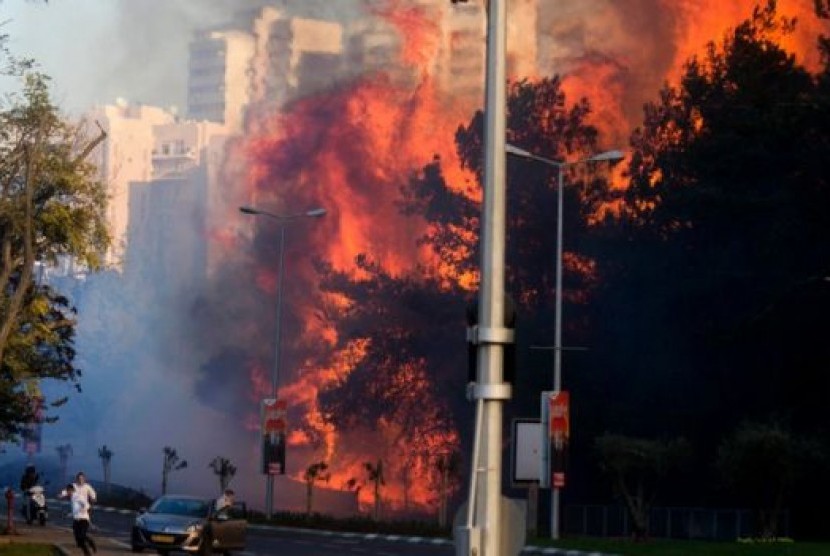 Warga Israel menyelamatkan diri dari kebakaran lahan.