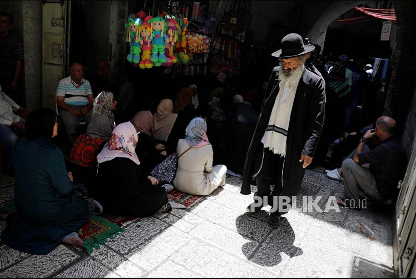 Warga Israel Ortodok melintasi warga Palestina di Kota Tua Yerusalem, Jumat (21/7)