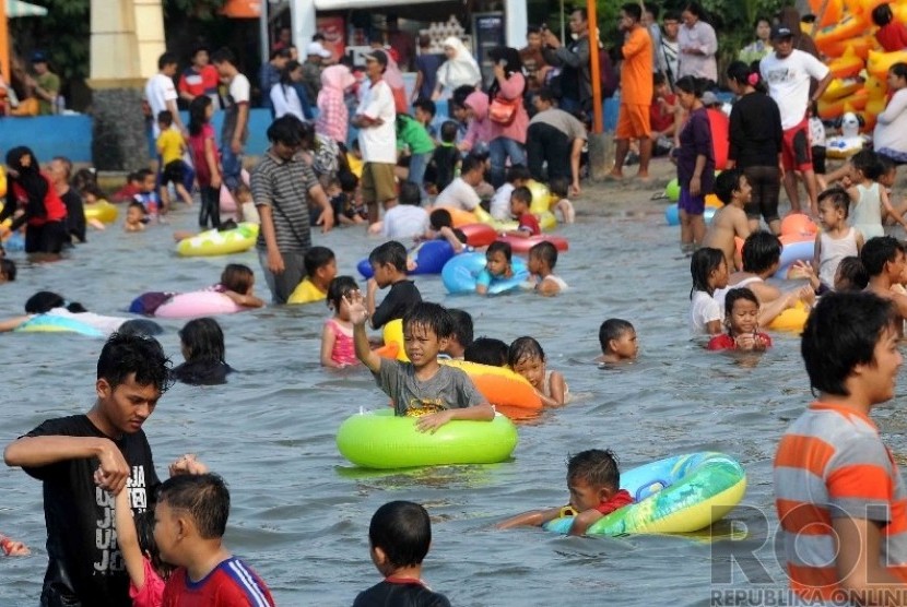 Warga Jakarta dan sekitarnya mengisi liburan dengan berenang di Pantai Festival Taman Impian Jaya Ancol (TIJA), Jakarta, Kamis (25/12). (Republika/Agung Supriyanto)