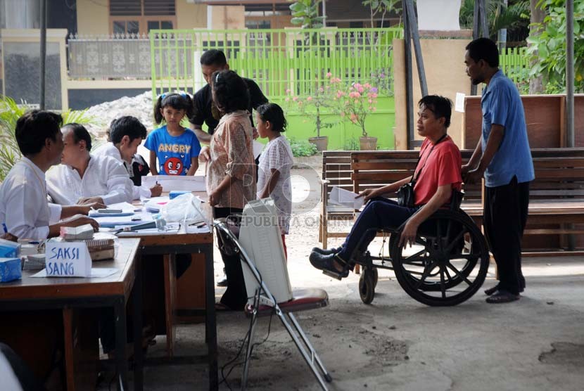  Warga Jakarta penyandang disabilitas tuna daksa dengan bantuan petugas, mengantre untuk menggunakan hak suaranya.  (Aditya Pradana Putra/Republika)