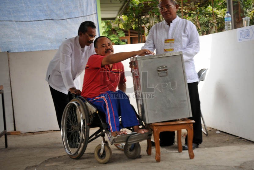  Warga Jakarta penyandang disabilitas tuna daksa dengan bantuan petugas menggunakan hak suaranya dalam Pilkada DKI Jakarta putaran kedua.  (Aditya Pradana Putra/Republika)
