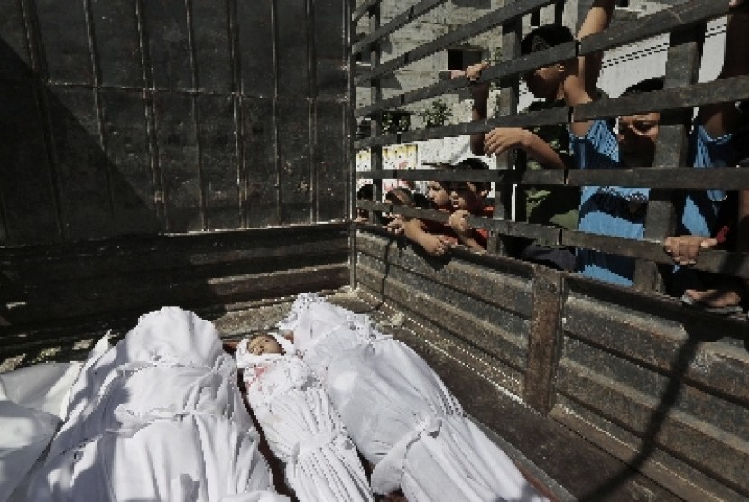 Warga Jalur Gaza yang meninggal akibat terkena serangan bom Israel diangkut ke truk sebelum dikubur.