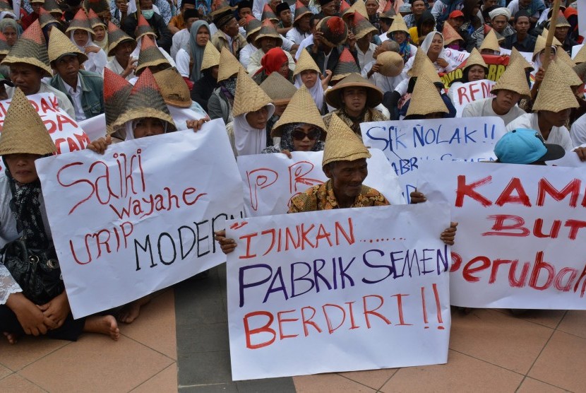 Warga Kabupaten Rembang pendukung pembangunan pabrik semen membentangkan poster saat berunjuk rasa di Semarang, Jawa Tengah, Selasa (13/12). 