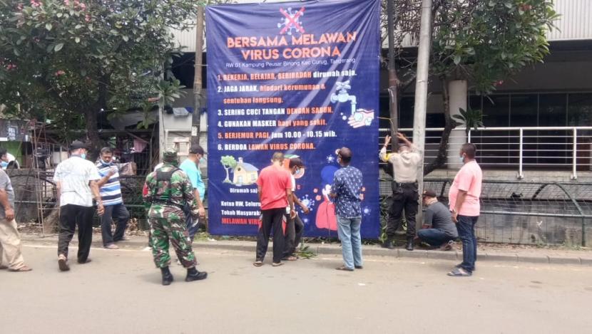 Warga kampung Peusar, Kecamatan Curug, Kabupaten Tangerang memasang baliho sebagai bentuk kampanye melawan virus corona.