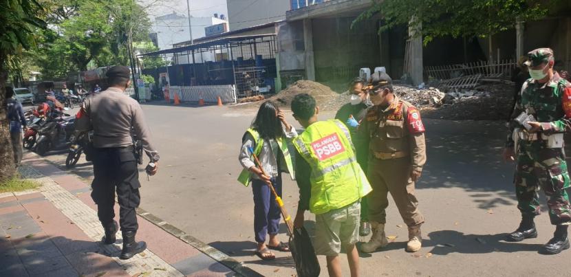 Warga kedapatan tak memakai masker disanksi bekerja sosial membersihkan fasilitas umum di kawasan Dadaha, Kota Tasikmalaya, Ahad (21/6).