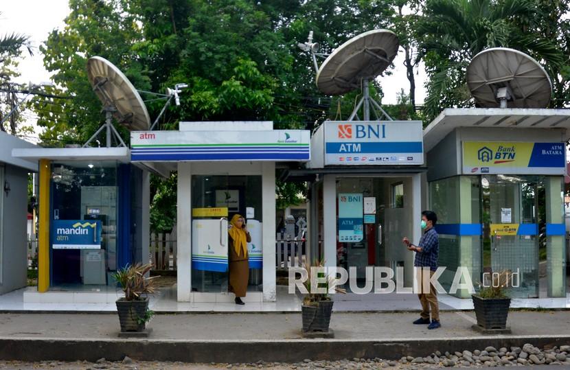 Warga keluar dari mesin Anjungan Tunai Mandiri (ATM) usai melakukan transaksi di halaman kantor Bupati Kabupaten Gowa, Sulawesi Selatan, Senin (31/5/2021). 