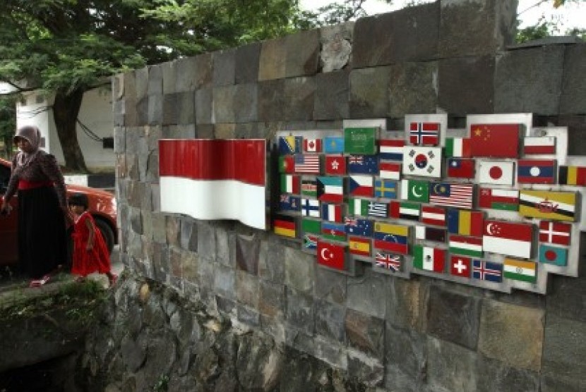 Warga keluar dari salah satu pintu gerbang Taman Terima Kasih Dunia yang menampilkan 53 plakat berbentuk kapal yang hampir tenggelam, juga dilengkapi dengan bendera negara yang membantu masyarakat Aceh 26 Desember 2014. (dok)