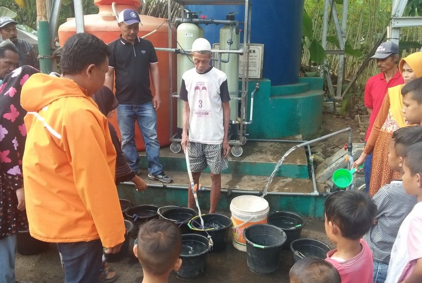 Warga Kelurahan SIngkup, Kecamatan Purbaratu, mengantre air di depan instalasi pengolahan air, Kamis (11/7).