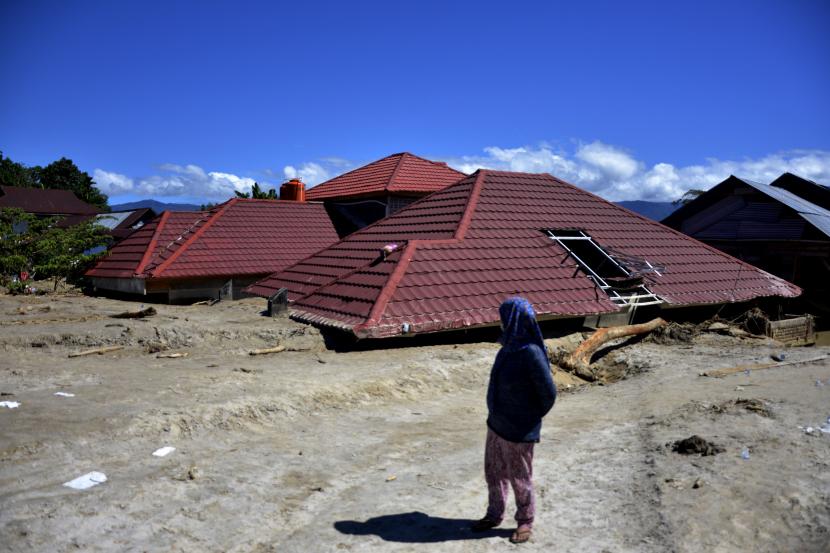 Warga korban banjir bandang melihat rumahnya yang hancur diterjang material lumpur di Masamba, Kabupaten Luwu Utara, Sulawesi Selatan, Jumat (17/7/2020). 