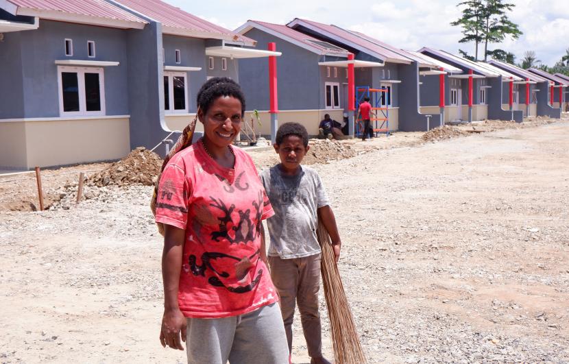 Warga korban banjir bandang Sentani melintas di depan rumah sehat di Doyo Baru, Distrik Waibu, Jayapura, Papua, Selasa (30/8/2022). Rumah sehat yang dibangun oleh Kementerian Sosial untuk korban banjir bandang di distrik Sentani pada 2019 lalu tersebut rencananya akan diresmikan oleh Presiden Joko Widodo pada 31 Agustus 2022. 