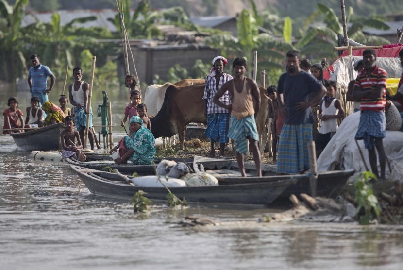  Warga korban banjir di Kampung Pokoria, sebelah timur utara Assam India, (14/8), menanti bantuan. Hujan deras telah mengakibatkan longsor dan banjir yang sudah menghilangkan nyawa di India, Nepal, dan Bangladesh.