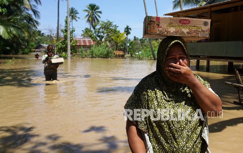 Warga korban banjir di Mamuju membawa bantuan logistik  (ilustrasi) 