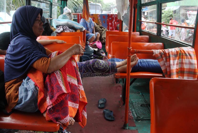   Warga korban banjir mengungsi di bus Metromini di Manggarai, Jakarta Selatan, Senin (13/1). (Republika/Yasin Habibi)