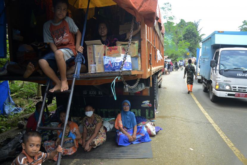 Warga korban gempa bumi yang mengungsi di pinggir jalan poros trans Sulawesi menunggu bantuan logistik di Kabupaten Mamuju, Sulawesi Barat, Minggu (20/1/2021). Bantuan untuk korban gempa bumi di Sulawesi Barat masih terus berdatangan dari sejumlah daerah.