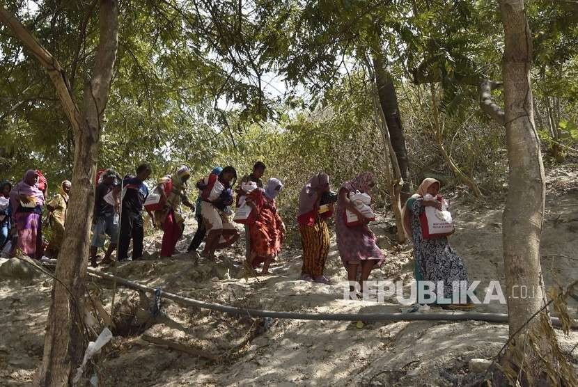 Warga korban gempa dan tsunami membawa bantuan dari Persiden Joko Widodo di Desa Loli Saluran, Donggala, Sulawesi Tengah, Rabu (3/10). 