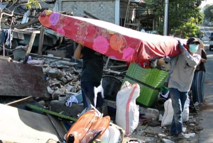 Warga korban gempa Lombok menyelamatkan benda yang masih bisa digunakan pascabencana.