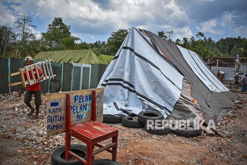 Warga korban gempa membangun hunian sementara yang terbuat dari sisa-sisa bahan bangunan dan terpal di Desa Dopang, Gunungsari, Lombok Barat, NTB, Ahad (23/9). 