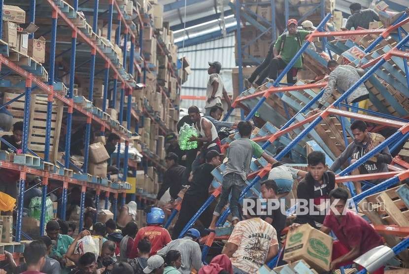 Warga korban gempa mengambil berbagai keperluan logistik di Mamboro, Palu Utara, Sulawesi Tengah, Senin (1/10). 