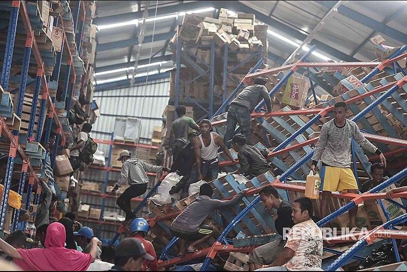 Warga korban gempa mengambil berbagai keperluan logistik di Mamboro, Palu Utara, Sulawesi Tengah, Senin (1/10). Warga di wilayah Palu Utara hingga Donggala bagian pantai Barat terpaksa mengambil berbagai kebutuhan tersebut karena bantuan belum sampai ke lokasi. 