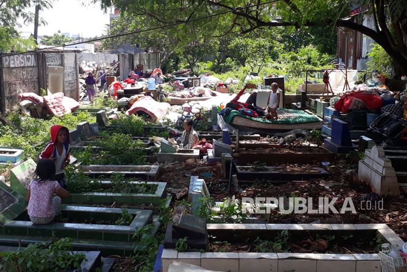 Warga korban penggusuran Kampung Palem Nuri, Kelurahan Panunggangan Barat, Kota Tangerang memilih bertahan dan tidur di atas pemakaman umum yang bersebelahan dengan lokasi penggusuran, Kamis (7/12).