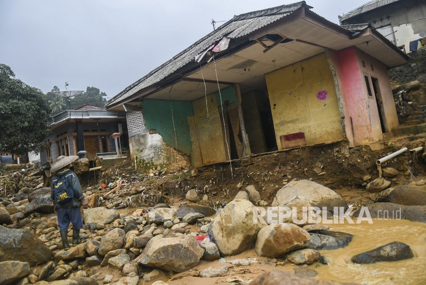 Warga korban tanah longsor dan banjir bandang mengamati sebuah rumah yang rusak di Desa Adat Urug, Kecamatan Sukajaya, Kabupaten Bogor, Jawa Barat, Jumat (10/1/2020).