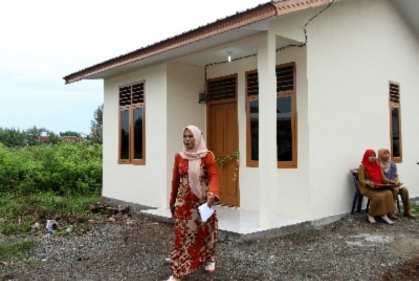 Warga korban tsunami melintas di depan rumah barunya bantuan Pemerintah Kota Banda Aceh di Gampong Ulee Lheu, Meuraxa.